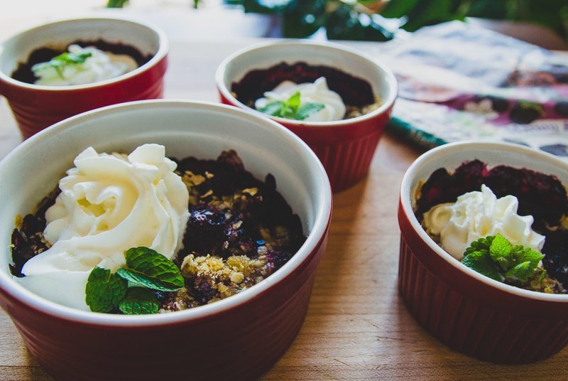 four servings of black raspberry cobbler topped with whipped cream and mint
