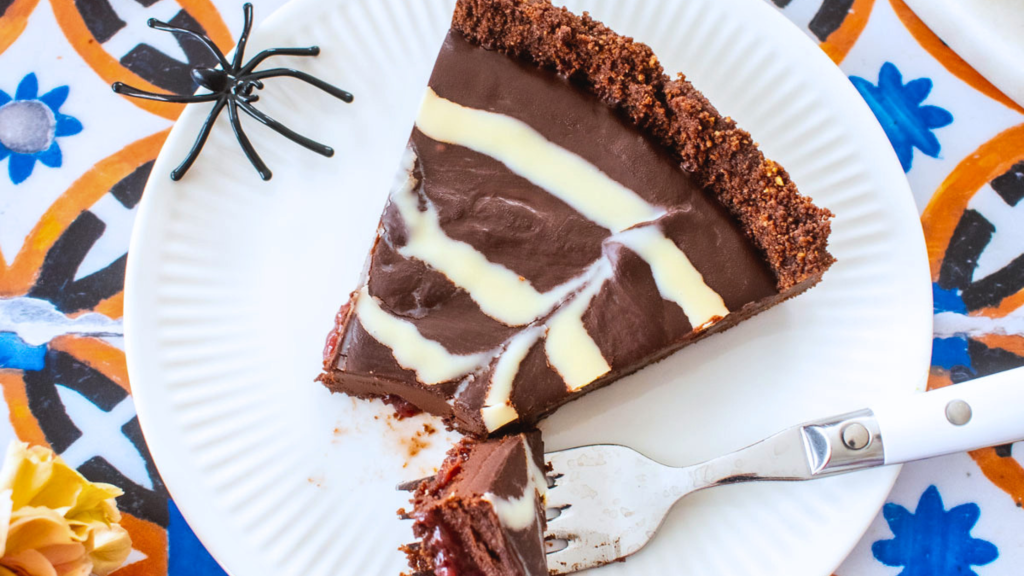 a slice of a chocolate strawberry spider tart