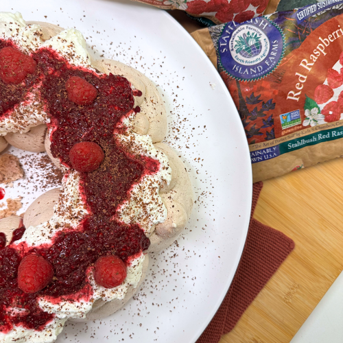 a chocolate pavlova wreath with raspberry jam with a bag of Stahlbush Island Farms Frozen Raspberries