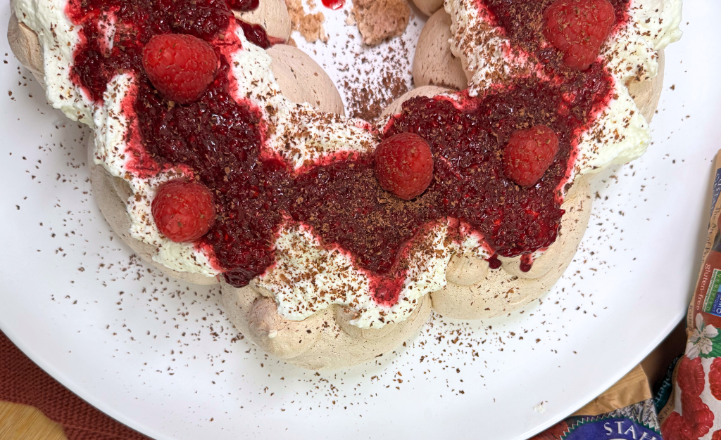 a chocolate pavlova wreath with raspberry jam with a bag of Stahlbush Island Farms Frozen Raspberries
