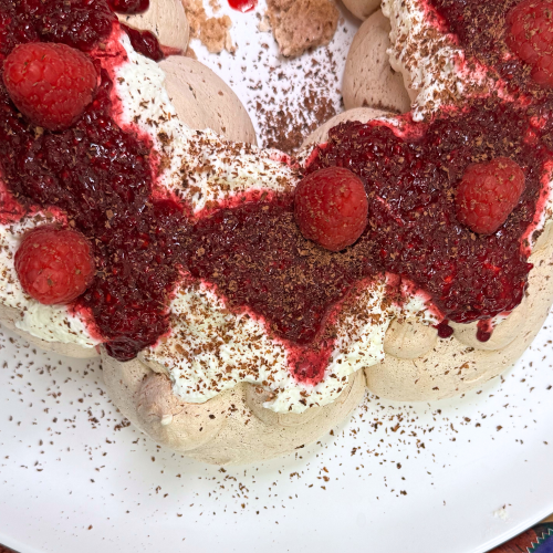 a chocolate pavlova wreath with raspberry jam with a bag of Stahlbush Island Farms Frozen Raspberries